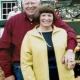 Smiling couple posing outdoors in front of house