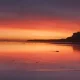 Vibrant sunset over calm beach shoreline