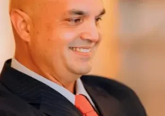 Smiling bald man in suit and red tie