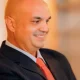Smiling bald man in suit and red tie