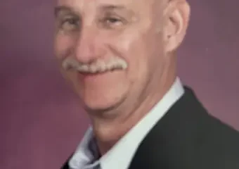 Smiling bald man with mustache in blazer