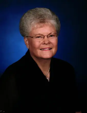 Smiling older woman with glasses against blue background