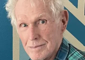Elderly man with white hair and plaid shirt