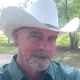 Man wearing white cowboy hat outdoors