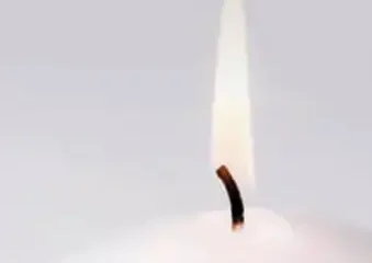Close-up of a lit white candle flame