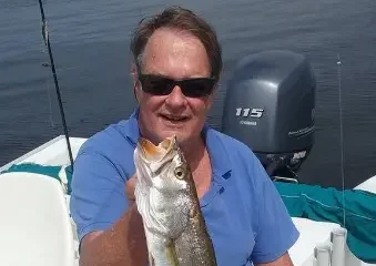 Man holding large fish on boat