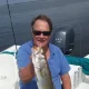 Man holding large fish on boat