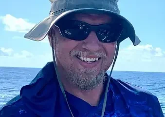 Man smiling on boat with ocean background