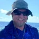 Man smiling on boat with ocean background