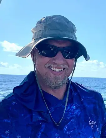 Man smiling on boat with ocean background