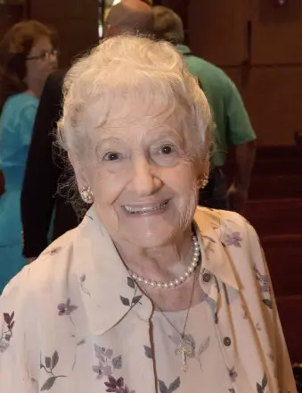 Smiling elderly woman wearing floral blouse and pearls