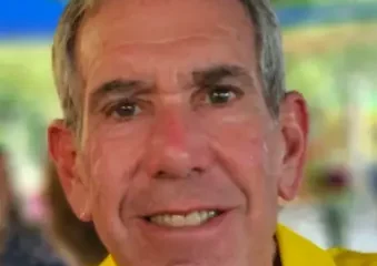 Close-up of smiling older man in yellow shirt