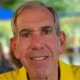 Close-up of smiling older man in yellow shirt