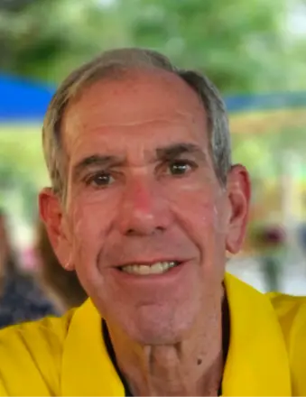 Close-up of smiling older man in yellow shirt