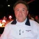 Man in white jacket at dim restaurant