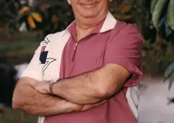 Man in pink polo standing outdoors