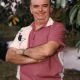 Man in pink polo standing outdoors