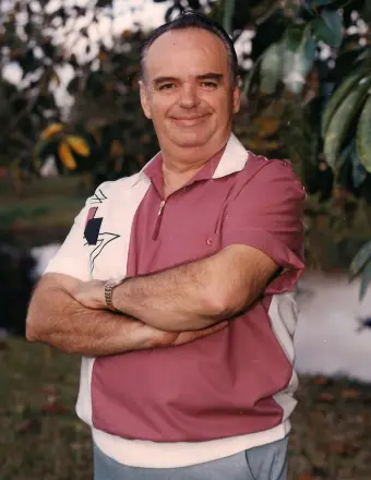 Man in pink polo standing outdoors