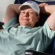 Man relaxing in chair wearing baseball cap indoors