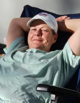 Man relaxing in chair wearing baseball cap indoors