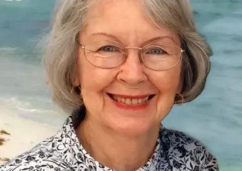 Smiling older woman with glasses at beach