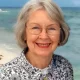 Smiling older woman with glasses at beach