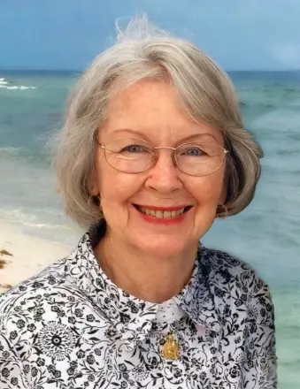 Smiling older woman with glasses at beach