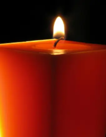 Red candle burning against dark background