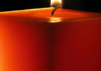 Lit red candle with glowing flame