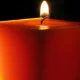 Lit red candle with glowing flame