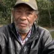 Older man wearing cap and leather jacket outdoors