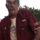Man with gray hair wearing red shirt outdoors