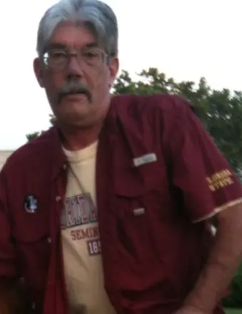 Man with gray hair wearing red shirt outdoors