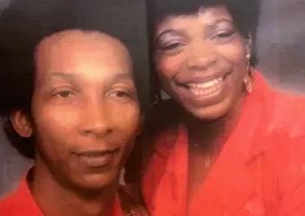 Two people in red outfits smiling together