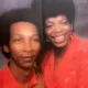 Two people in red outfits smiling together