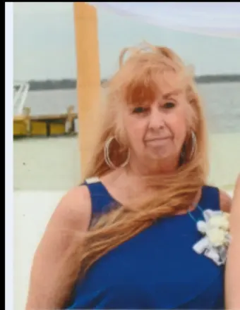 Woman in blue dress by waterfront dock