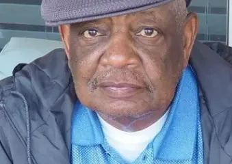 Older man wearing flat cap and blue shirt