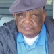Older man wearing flat cap and blue shirt