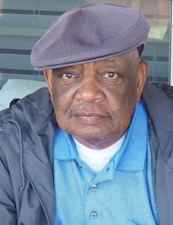 Older man wearing flat cap and blue shirt