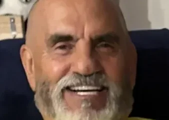Smiling bald man with white beard indoors
