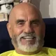 Smiling bald man with white beard indoors