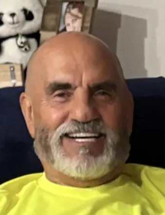 Smiling bald man with white beard indoors