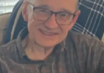 Smiling elderly man wearing glasses indoors