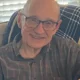 Smiling elderly man wearing glasses indoors