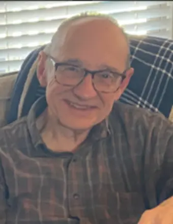 Smiling elderly man wearing glasses indoors