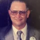 Man in suit with glasses and lapel pin
