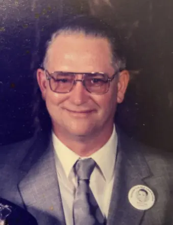 Man in suit with glasses and lapel pin