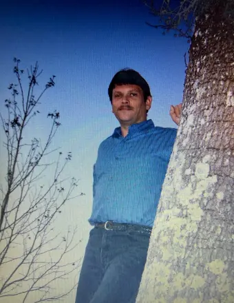 Man leaning against tree at dusk