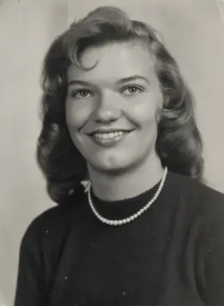 Black-and-white portrait of smiling young woman with pearls