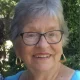 Smiling elderly woman with glasses outdoors